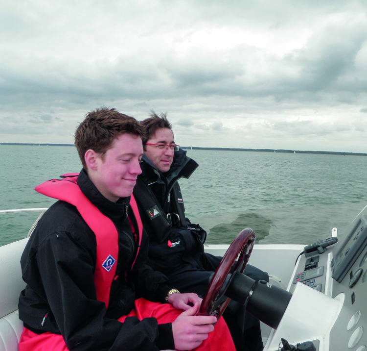 Two sailors sat at the helm of powerboat 