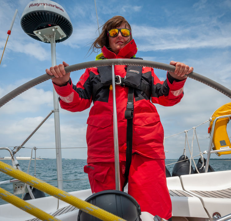 Sailor stood at the helm of the boat