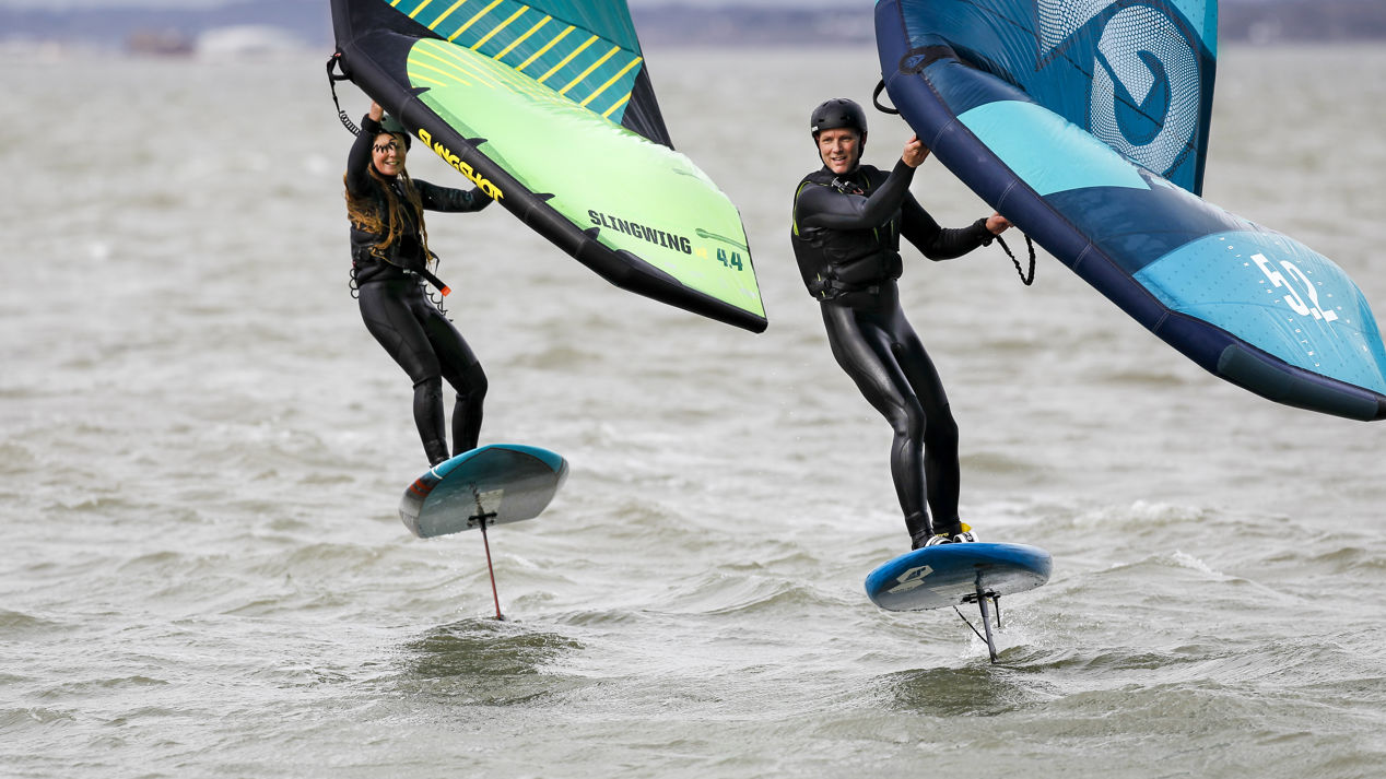 two RYA wing surfers cutting through wind and waves