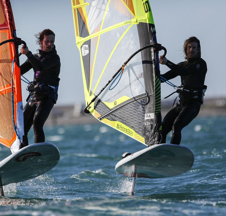 Windsurfers cutting through blue waters