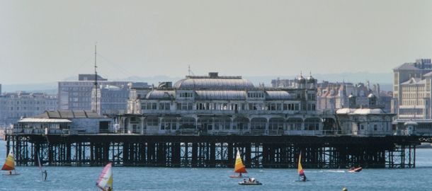 Wide shot of windsurfers in front of pier 
