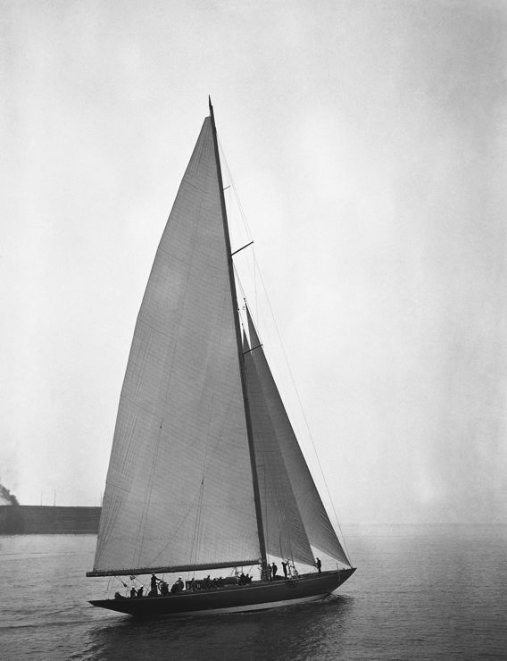 Black and white image of a single sailing boat travelling through the water