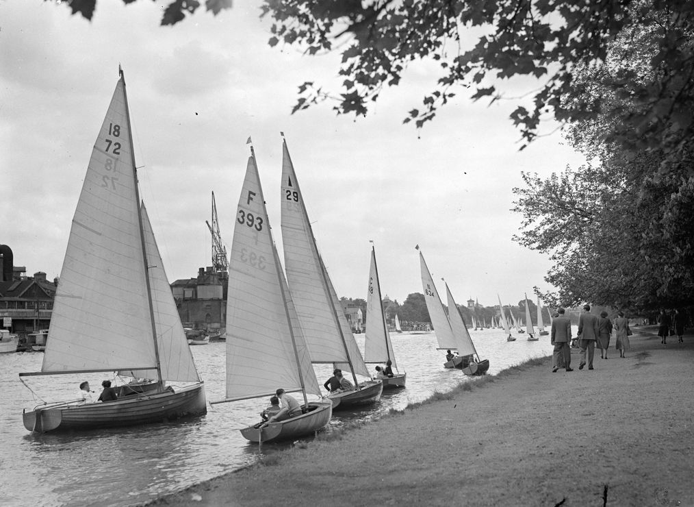 Black and white image of multiple dinghies on the shore