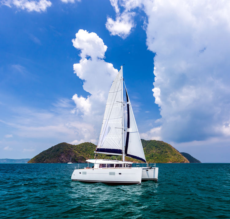 White catamaran on ripples the water in Andaman sea with blue sky and clouds at Phuket, Thailand