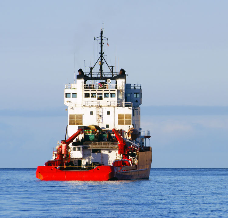 Large workboat sailing away in the distance