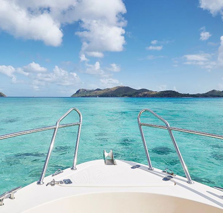 close up of bow of ship at sea with turquoise water 