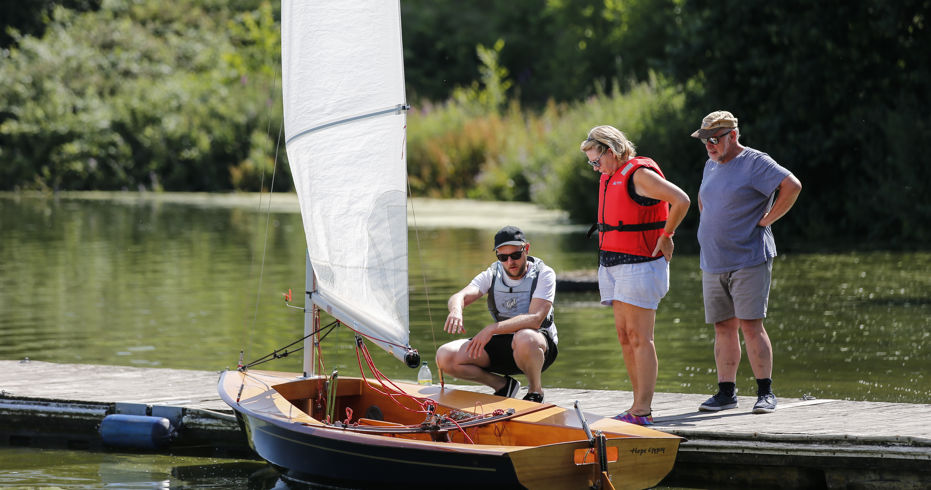 Long shot of a man educating two sailors on boating