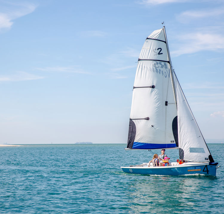 family in an RS Dinghy on the open water, light airs, starboard mark