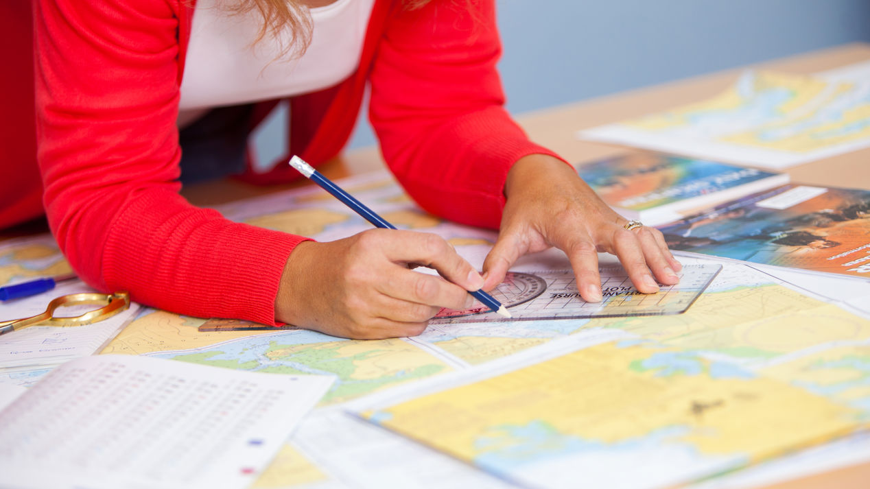 close up shot of compass and map in Yachtmaster Ocean Theory Chartwork