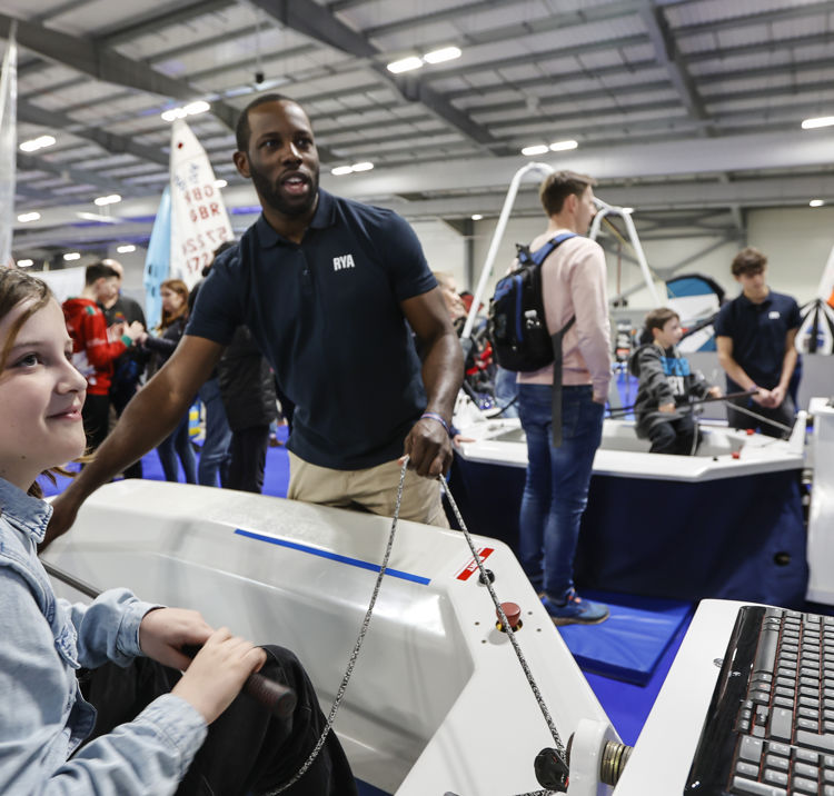 Mid shot of child taking part in an interactive sailing simulator at the Dinghy Show