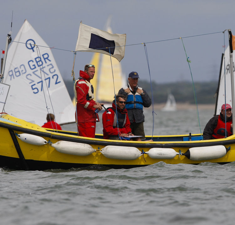 Race officials on yellow sail boat