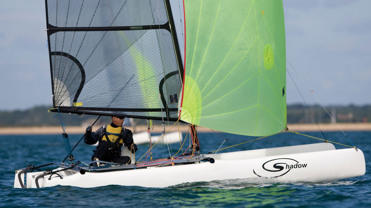 Solo sailor on multihull in calm weather and blue waters