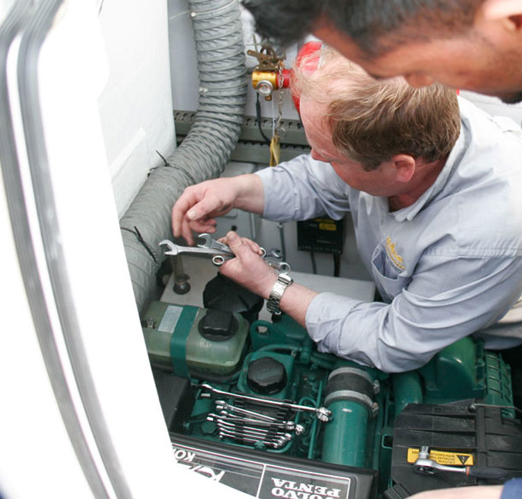 Two men fixing a boat engine 