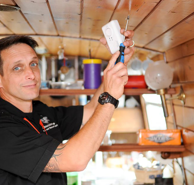 Mid shot of man fitting a carbon monoxide alarm