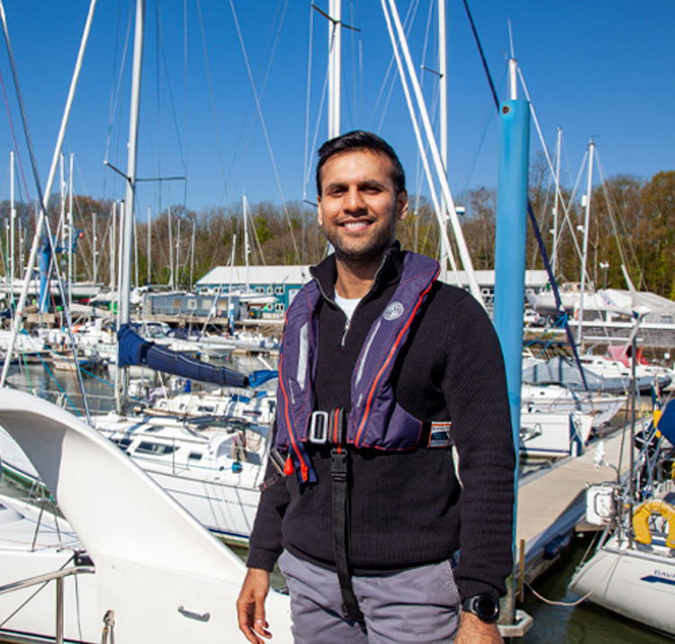 sailor posing and smiling in front of boat