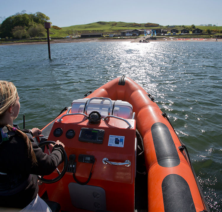 Woman in powerboat sailing towards sunny horizon
