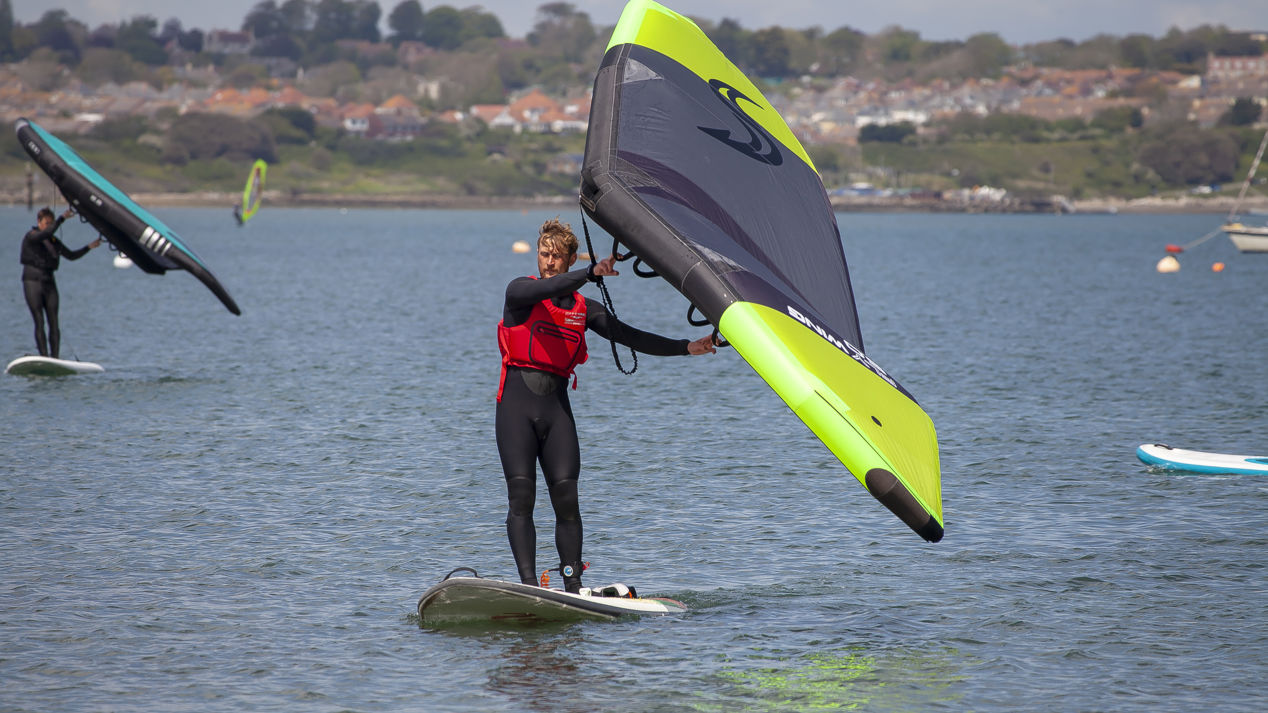 wide shot of windsurfer on coast