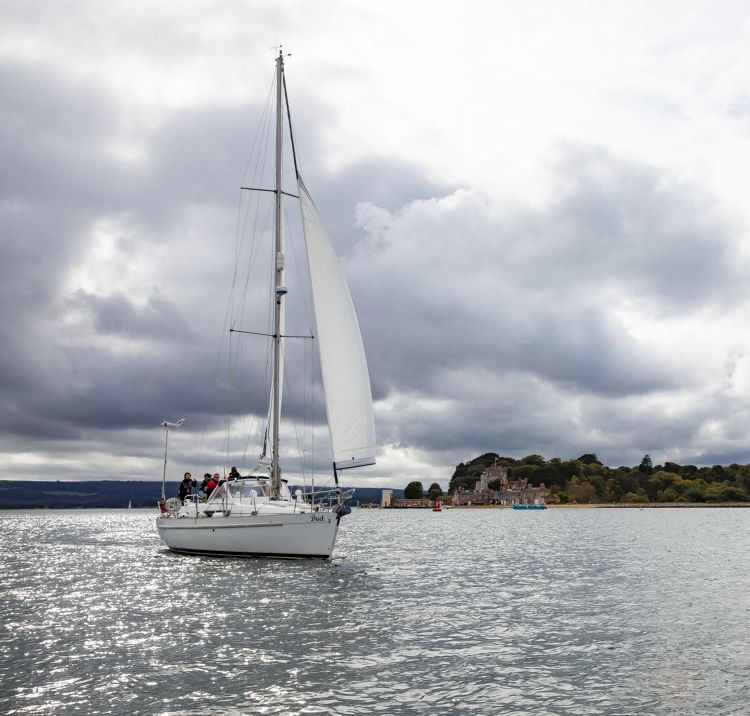 wide shot of yacht sailing across lake