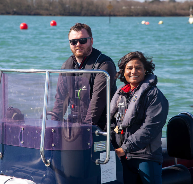 Mid shot image of two sailors on boat smiling at camera