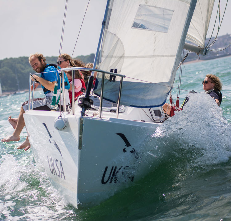 Sailors sat on the edge of sail boat