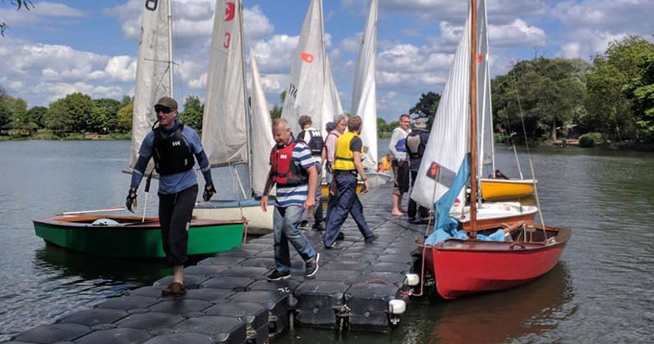 Man on deck with moored dinghies