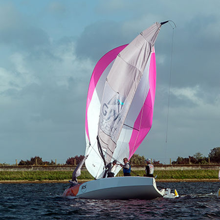 mid shot of boat with pink edged sails