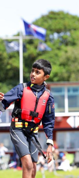 two young children on shore talking at a sailing event