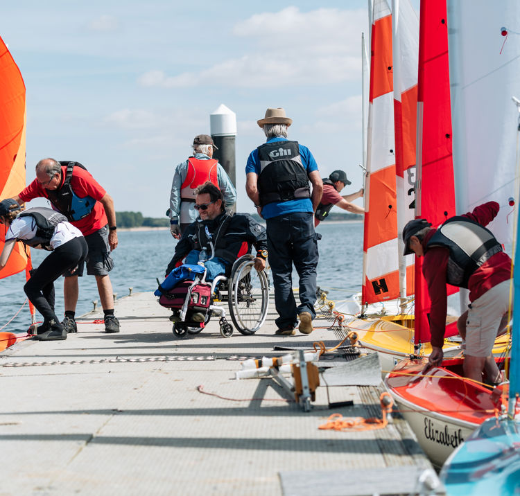numerous people on the dock checking the dinghies 