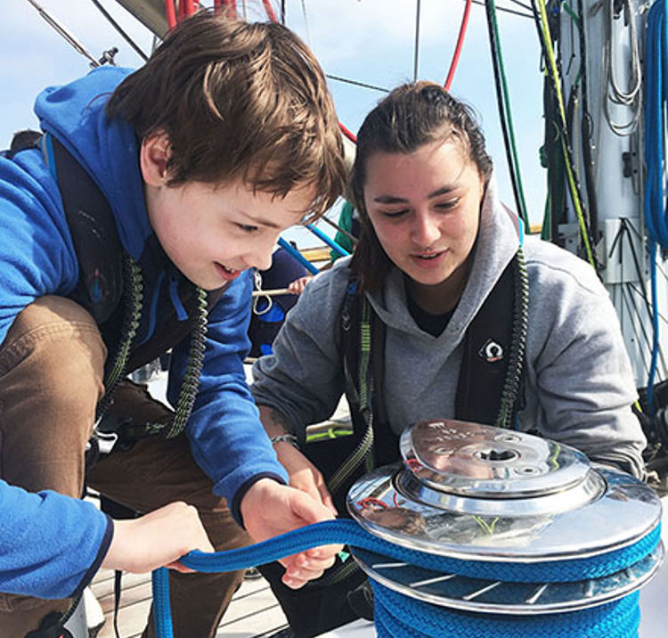 Youth sailors enjoying a session the water learning about rope work
