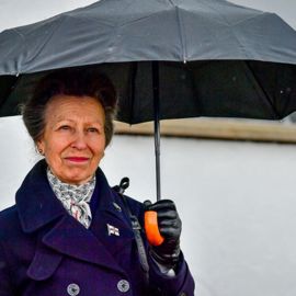 HRH Princess Anne holding an umbrella in the rain 
