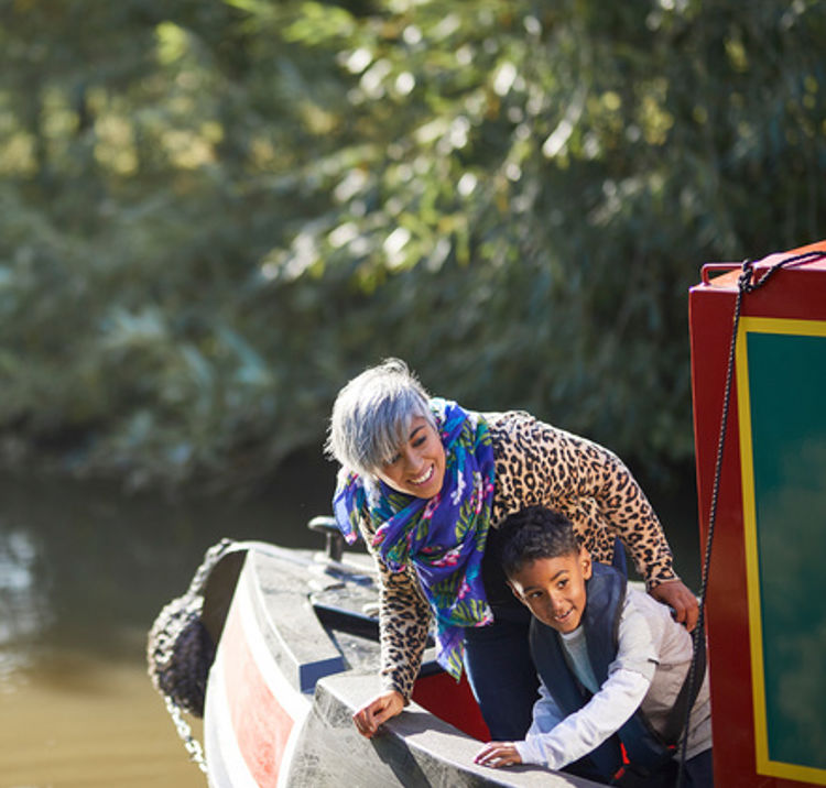 mother and son looking over the side of a canal boat