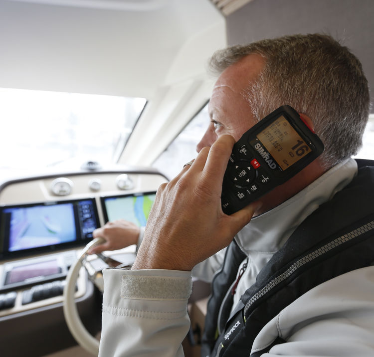 An image showing a VHF radio being held in a hand.