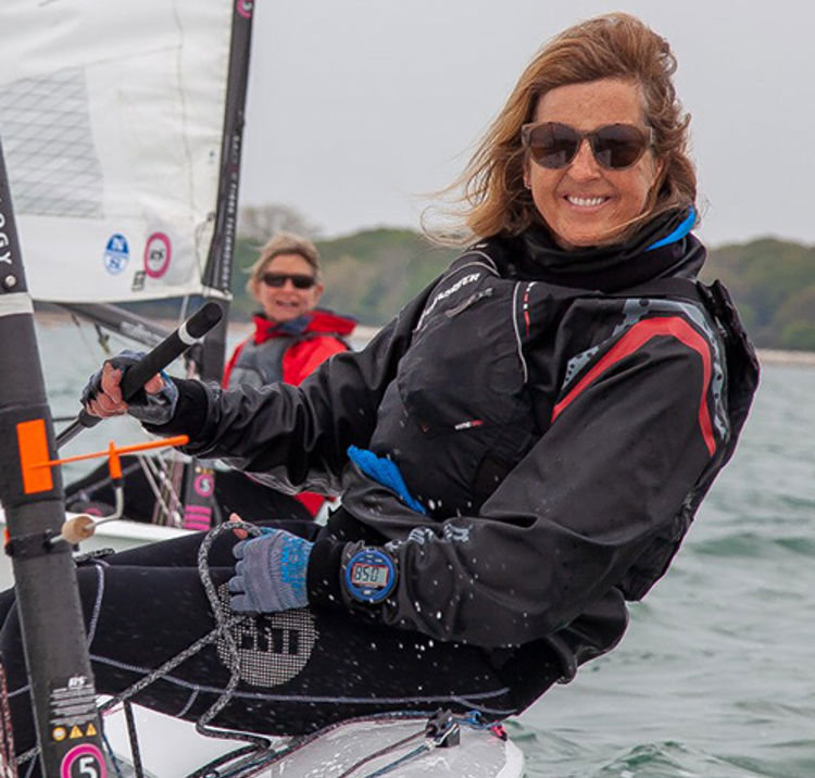 woman smiling at the camera from her dinghy 