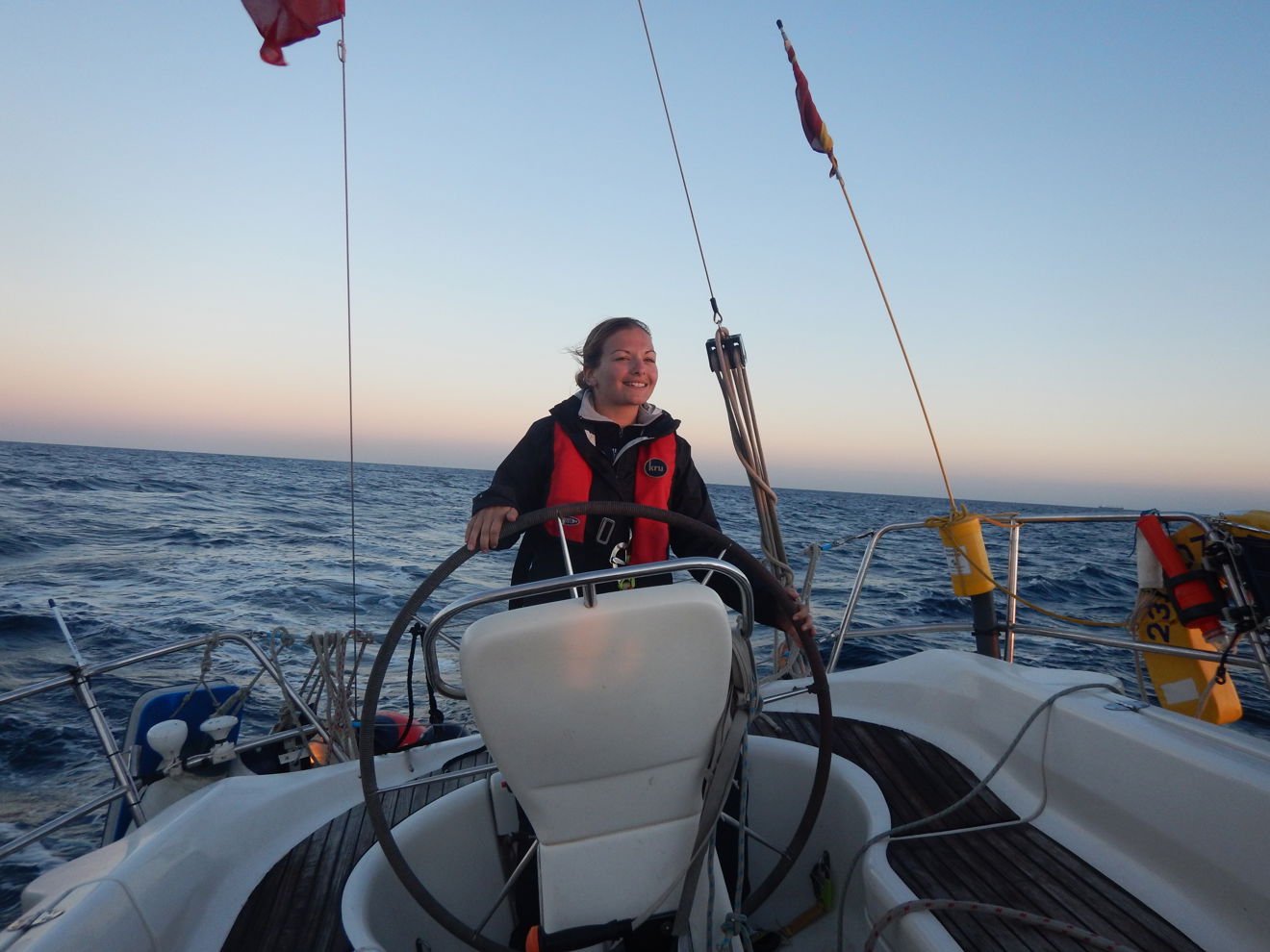 Woman steering a boat and smiling