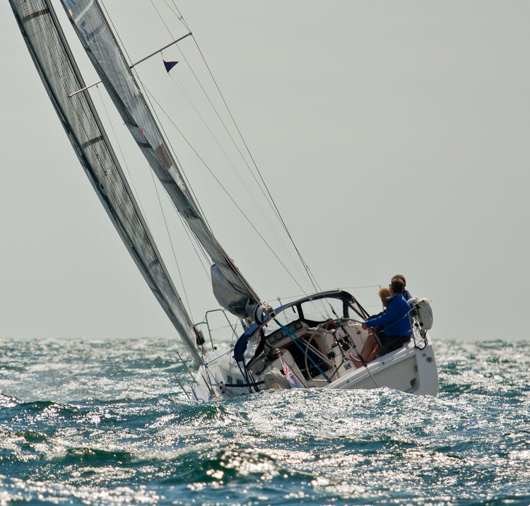 A yacht sailing through crashing waves