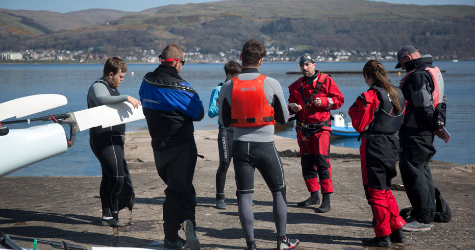 Long shot of group of sailors being given an introduction to a sailing course