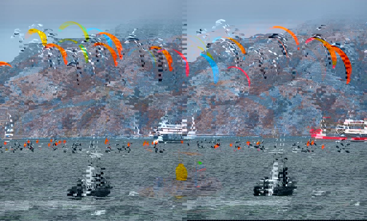 Kite surfers racing with a support rib