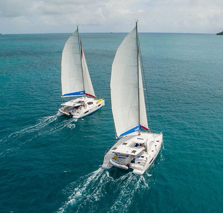 two yachts sailing side by side in the ocean