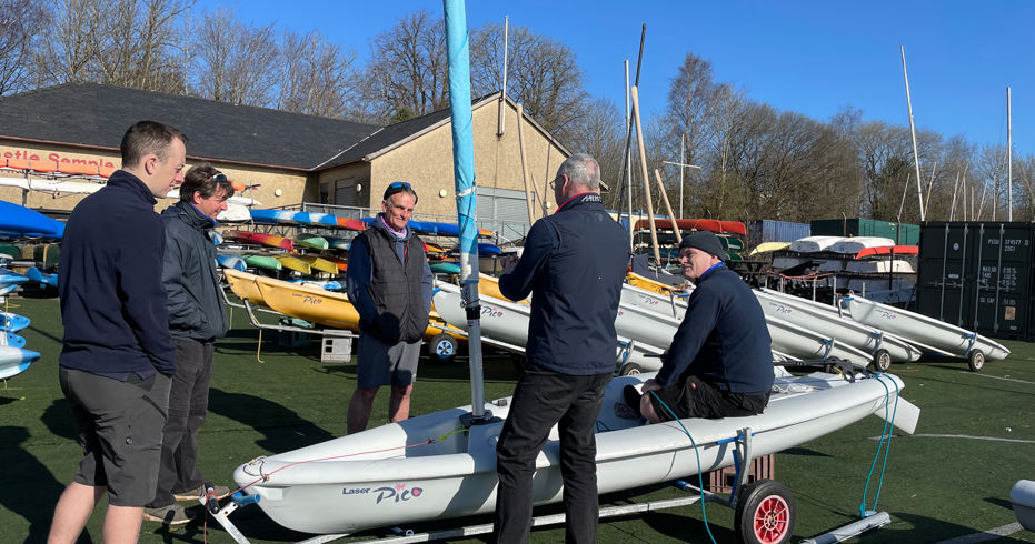instructors stood around a dinghy on land